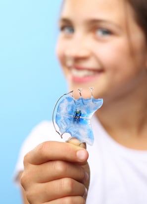 Young person holding up Hawley-style retainer.